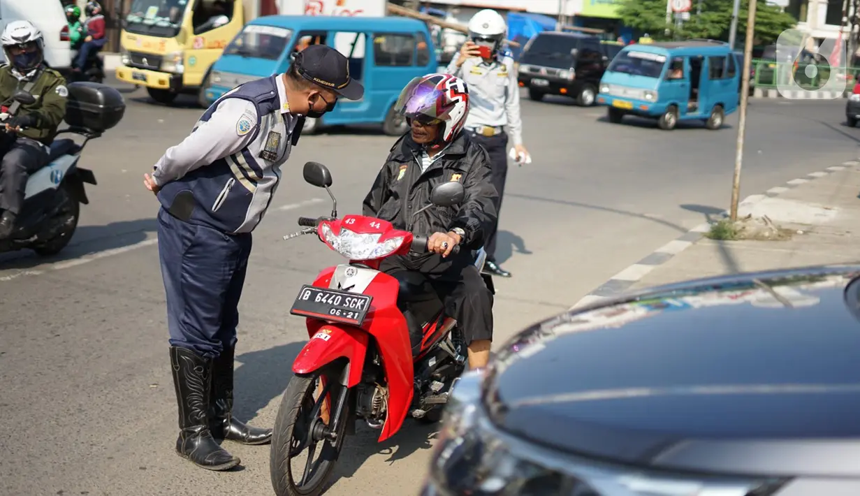 Petugas Dishub melakukan sosialisasi penggunaan masker kepada pengendara sepeda motor di kawasan Depok, Jawa Barat, Senin (20/7/2020). Warga yang tidak mengenakan masker nantinya akan dikenai denda Rp 50 ribu atau sanksi sosial sesuai Perwali Nomor 45 tahun 2020. (Liputan6.com/Immanuel Antonius)