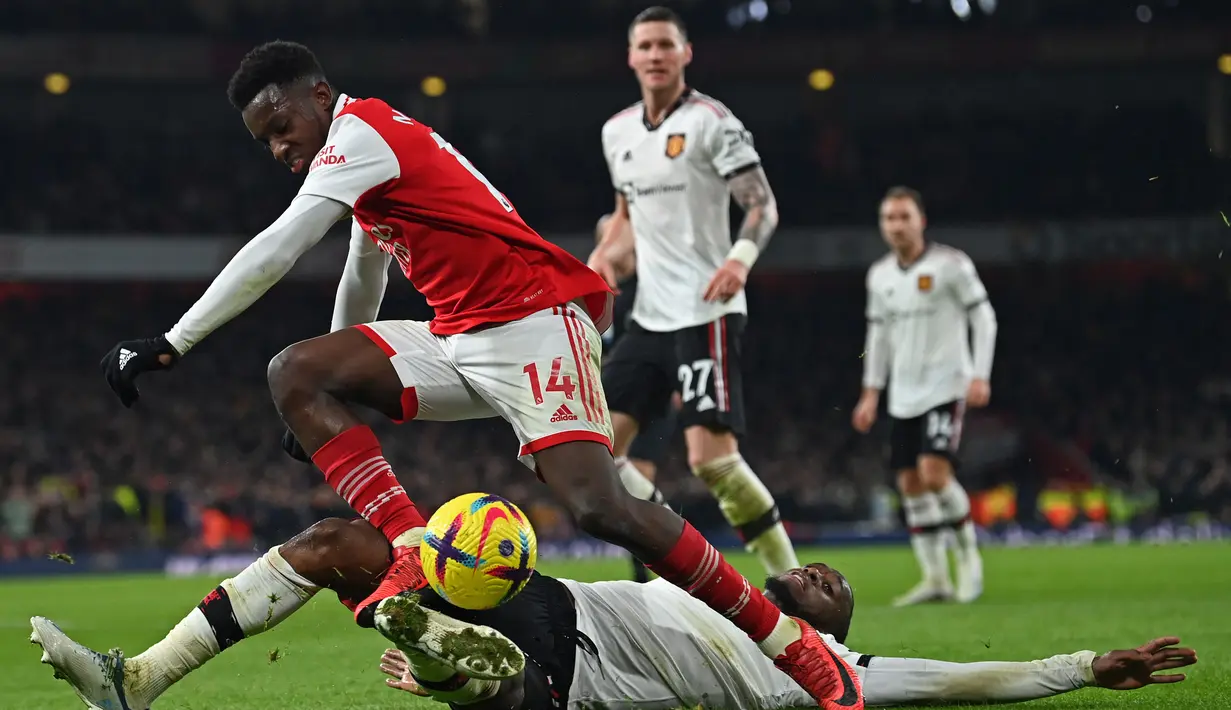 Penyerang Arsenal, Eddie Nketiah berusaha melewati bek Manchester United, Aaron Wan-Bissaka pada pertandingan lanjutan Liga Inggris di stadion Emirates di London, Minggu (22/1/2023). Nketiah sukses melakukan comeback pada menit ke-90 setelah memaksimalkan assist dari Martin Odeegard, sekaligus mengakhiri pertandingan untuk kemenangan 3-2 Arsenal atas Manchester United. (AFP/Glyn Kirk)