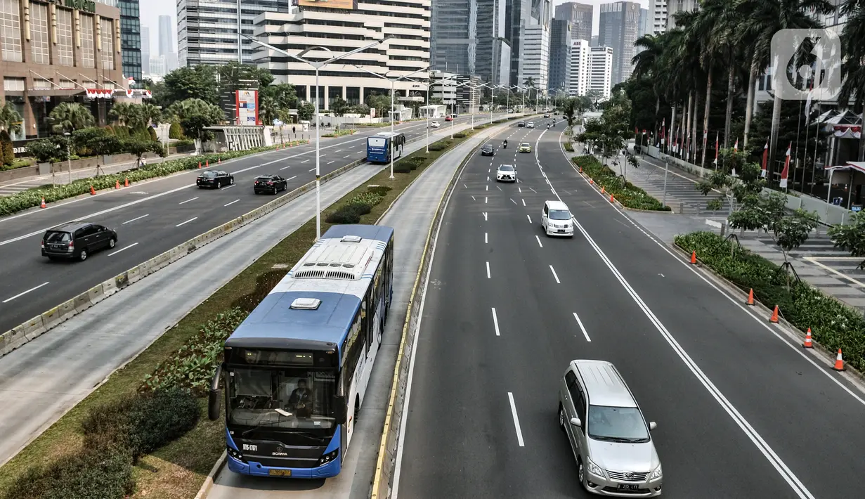Bus Transjakarta saat melintas di Jalan Sudirman, Jakarta, Minggu (2/8/2020). PT Transjakarta akan menambah armada sebanyak 155 mengantisipasi lonjakan pelanggan saat diberlakukan kebijakan ganjil genap di sejumlah ruas jalan utama Jakarta pada Senin, 3 Agustus 2020. (merdeka.com/Iqbal Nugroho)