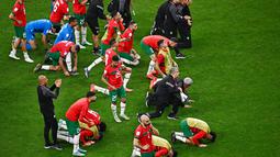 Meski pada laga tersebut mereka tumbang dua gol tanpa balas, namun para pemain beserta staf timnas Maroko tetap melakukan sujud syukur seperti yang biasa mereka lakukan sebelumnya. (AFP/Anne-Christine Poujoulat)