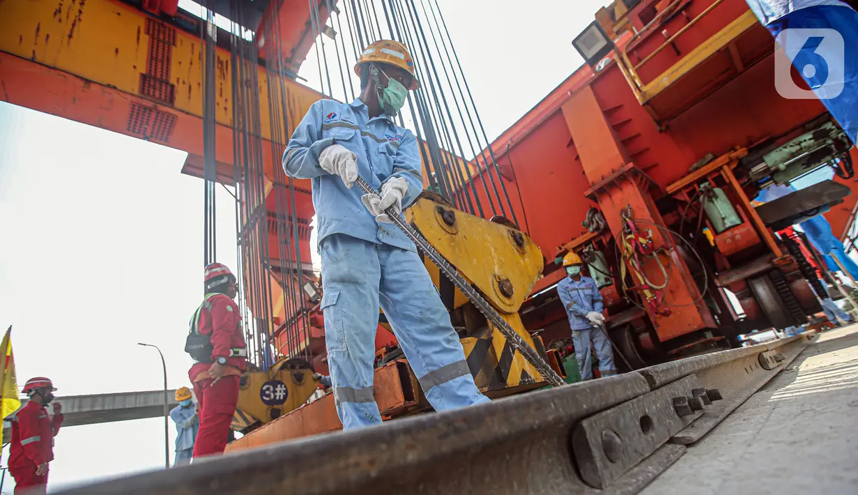 Pekerja Kereta Cepat Jakarta-Bandung (KCJB) menyelesaikan pemasangan girder box Casting Yard #1 di kawasan Jatibening Baru, Bekasi, Jawa Barat, Senin (27/6/2022). Sebelumnya, pemasangan girder box dari CY#1 arah Bandung sudah selesai pada 28 Mei 2021. (Liputan6.com/Faizal Fanani)