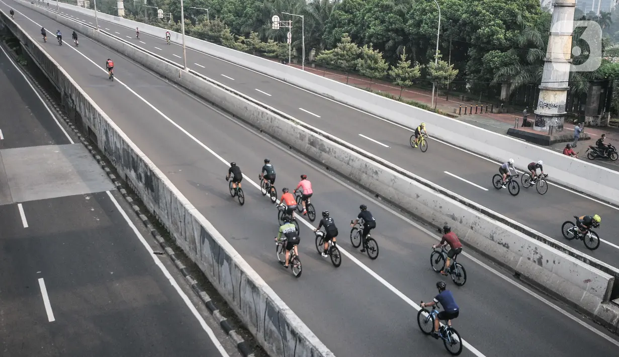 Pesepeda melintasi Jalan Layang Non Tol (JLNT) Kampung Melayu-Tanah Abang saat uji coba jalur sepeda balap atau Road Bike, Jakarta, Minggu (23/5/2021). Tidak hanya pesepeda balap, pengguna sepeda jenis lain pun turut meramaikan uji coba ini. (merdeka.com/Iqbal S Nugroho)