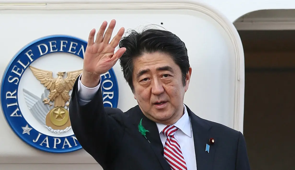 Dalam file foto pada 21 April 2015, Shinzo Abe yang masih menjabat sebagai Perdana Menteri Jepang melambai saat berangkat menuju Indonesia di Bandara Internasional Tokyo di Tokyo. Shinzo Abe dikabarkan telah meninggal dunia, setelah menjalani perawatan beberapa saat akibat akibat penembakan di Nara pada Jumat, 8 Juli 2022. (JIJI PRESS / AFP)