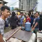 Adalah Mehdi (22) bersama rekannya yang mengoperasikan 'perahu' dadakan tersebut untuk membantu aktivitas warga yang terjebak banjir. (Foto: Merdeka.com)