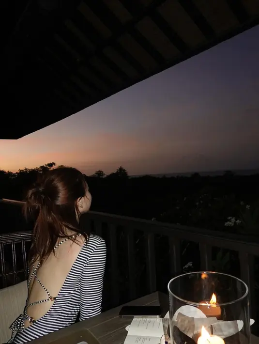 Menikmati pemandangan sunset yang indah, Nayeon tampil santai dengan backless striped top nuansa monokrom. [@nayeonyny]