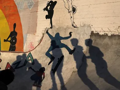 Bayangan anggota Gaza Skate Team ketika mempraktekkan keterampilan skateboard dan sepatu roda di sebuah pelabuhan di Kota Gaza pada 8 Maret 2019. Mengambil nama “Gaza skate team”, kelompok yang beranggotakan 20 remaja itu menggelar latihan mingguan yang dipandu dua pelatih. (REUTERS/Mohammed Salem)