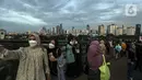 Warga berswafoto saat mengisi libur Tahun Baru dengan menikmati pemandangan Kota Jakarta dari Skywalk Senayan Park, Sabtu (1/1/2022). Skywalk Senayan Park kini menjadi salah satu tempat wisata pilihan warga Jakarta lantaran pemandangannya yang instagramable. (Liputan6.com/Johan Tallo)