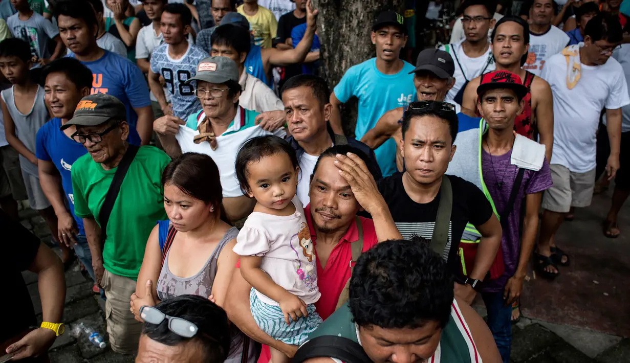 Warga Filipina menyaksikan petinju idola mereka, Manny Pacquiao, melawan petinju Australia Jeff Horn, pada perebutan gelar kelas welter WBO, di sebuah taman di Manila, Minggu (2/7). Horn mengalahkan Pacquiao dalam pertarungan 12 ronde. (Noel CELIS/AFP)