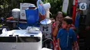 Warga duduk dekat barang-barang saat bangunannya terdampak proyek sodetan Ciliwung menuju Kanal Banjir Timur (KBT) di Kelurahan Cipinang Besar Selatan, Jakarta, Kamis (12/1/2023). Pemprov DKI mempercepat pembangunan sodetan kali Ciliwung menuju Kanal Banjir Timur (KBT) dengan tujuan mampu mengurangi dampak banjir dengan volume 60 kubik per detik. (merdeka.com/Imam Buhori)