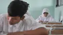Seorang ibu terlihat mengerjakan soal Ujian Nasional (UN) kesetaraan paket B di SMPN 80 Jakarta, Senin (4/5/2015). Sebanyak 378 peserta, termasuk peserta berusia lanjut mengikuti UN di hari pertama tersebut. (Liputan6.com/Johan Tallo)