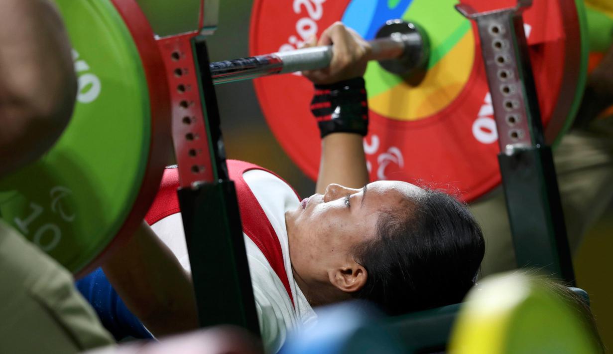 Atlet Indonesia, Ni Nengah Widiasih berusaha mengangkat beban seberat 95 kg pada cabang angkat berat di kelas -41 kg, di Paralimpiade 2016 Rio de Janeiro, Kamis (8/9). Ni Nengah mempersembahkan medali pertama untuk Indonesia. (REUTERS/Ueslei Marcelino)