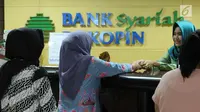 Nasabah melakukan transaksi di Bank Bukopin Syariah, Jakarta, Selasa (30/1). Data OJK yang terekam sampai Oktober 2017 mencatat, pertumbuhan aset perbankan syariah mencapai 19,79% secara tahunan menjadi Rp 395,89 triliun. (Liputan6.com/Angga Yuniar)