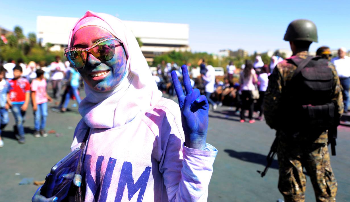 Seorang peserta berlumuran bubuk warna saat merayakan 'I Love Damaskus' di Umayyah Square Damaskus, Suriah, Jumat (7/10). (REUTERS / Omar Sanadiki)