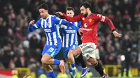 Pemain MU, Bruno Fernandes (kanan), berupaya lepas dari penjagaan pemain Brighton & Hove Albion pada lanjutan Piala FA 2025/2026, Minggu (11/1/2026) malam WIB. (PETER POWELL / AFP)