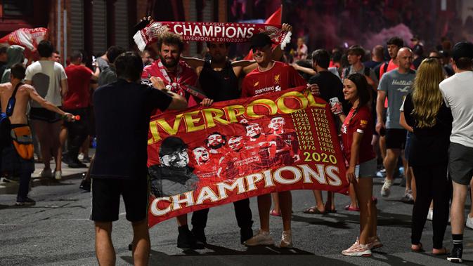 Para fans merayakan Liverpool memenangkan gelar juara Liga Primer Inggris di luar stadion Anfield di Liverpoo (25/6/2020). Liverpool meraih mahkota juara Liga Premier Inggris setelah mengakhiri gelar selama 30 tahun penantian.  (AFP Photo/Paul Ellis)