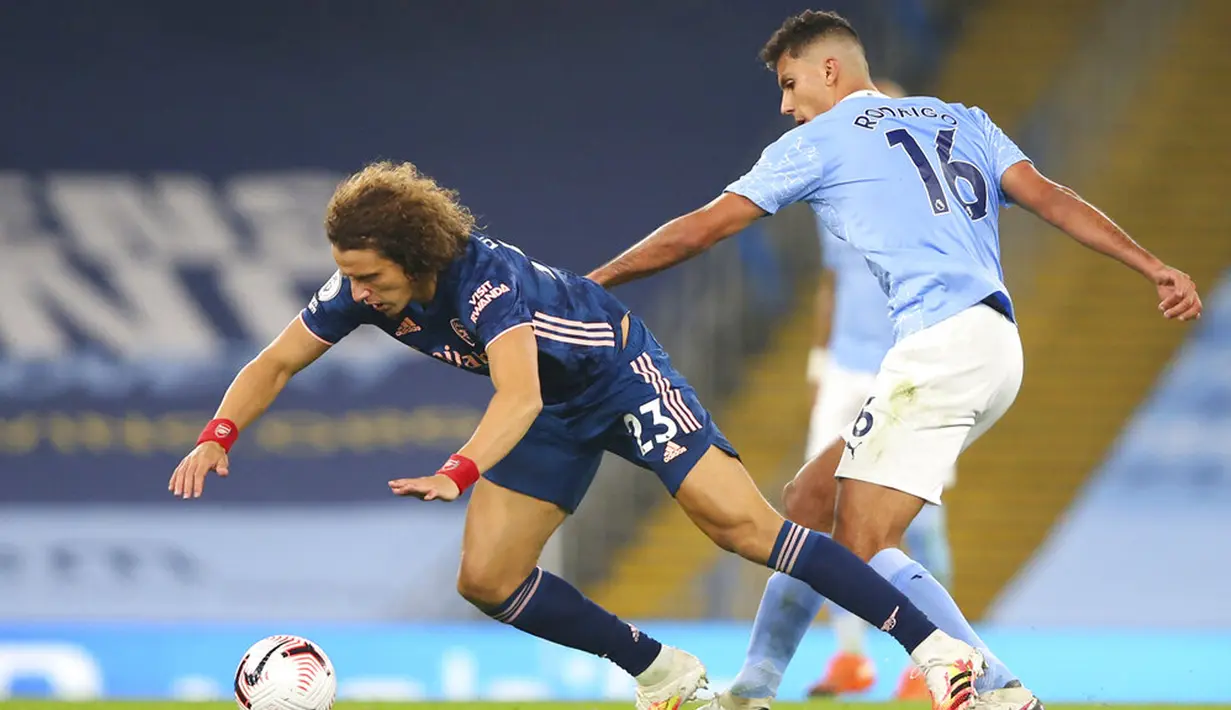 Pemain Arsenal David Luiz (kiri) berebutbola dengan pemain Manchester City Rodrigo pada pertandingan Liga Premier Inggris di Etihad Stadium, Manchester, Inggris, Sabtu (17/10/2020). Manchester City menang 1-0. (Alex Livesey/Pool via AP)