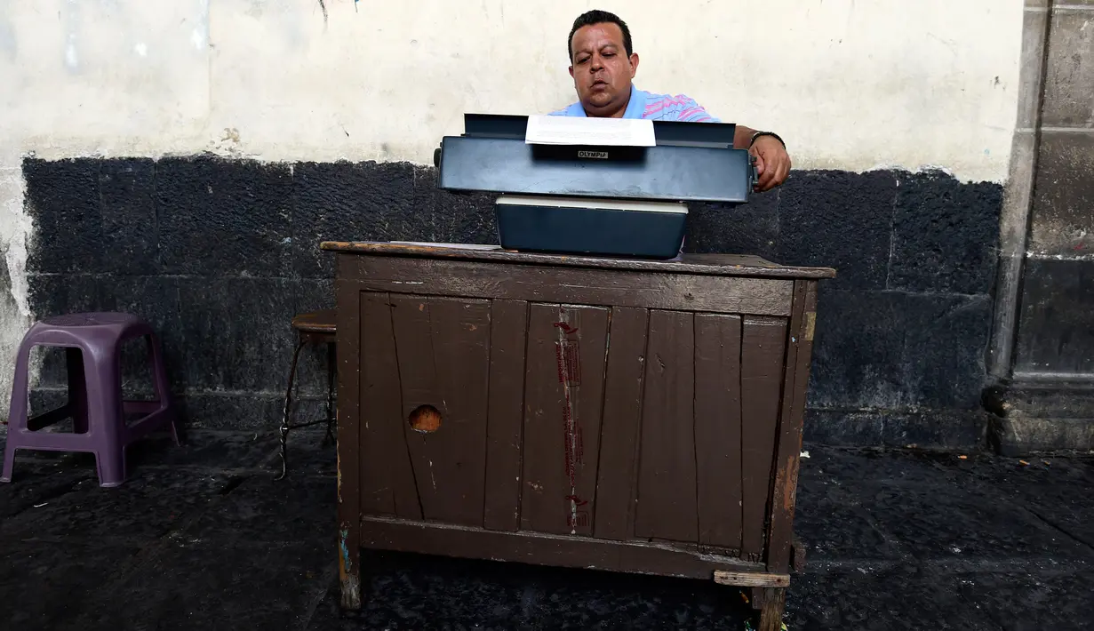 Seorang notaris serius menulis dokumen di Santo Domingo Square, Meksiko, (23/8). Notaris yang berada di pinggir jalan ini menerima jasa menulis surat terkait hukum perdata, lamaran kerja, wasiat, bahkan surat cinta. (AFP PHOTO/ALFREDO ESTRELLA)