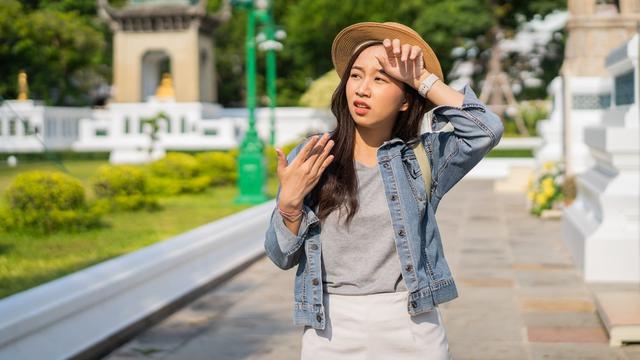 perempuan traveling jalan-jalan kepanasan siang terik matahari panas