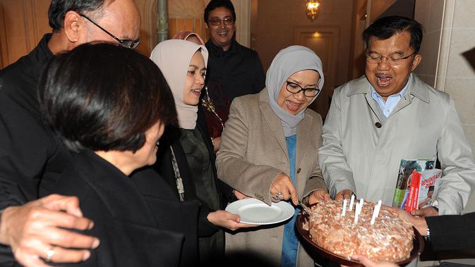 Mufidah Kalla memotong kue dan memberikannya kepada Wakil Presiden Jusuf Kalla seusai acara kejutan ulang tahun ke-77 di Jenewa, Swiss, Rabu (15/5/2019). JK berkunjung ke Swiss untuk menghadiri sebuah pertemuan yang diinisiasi PBB dengan bahasan penanganan bencana. (Liputan6.com/Tim Media Wapres)