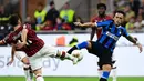 Striker Inter Milan, Lautaro Martinez, berebut bola dengan gelandang AC Milan, Hakan Calhanoglu, pada laga Serie A di Stadion San Siro, Milan, Sabtu (21/9). Milan kalah 0-2 dari Inter. (AFP/Miguel Medina)
