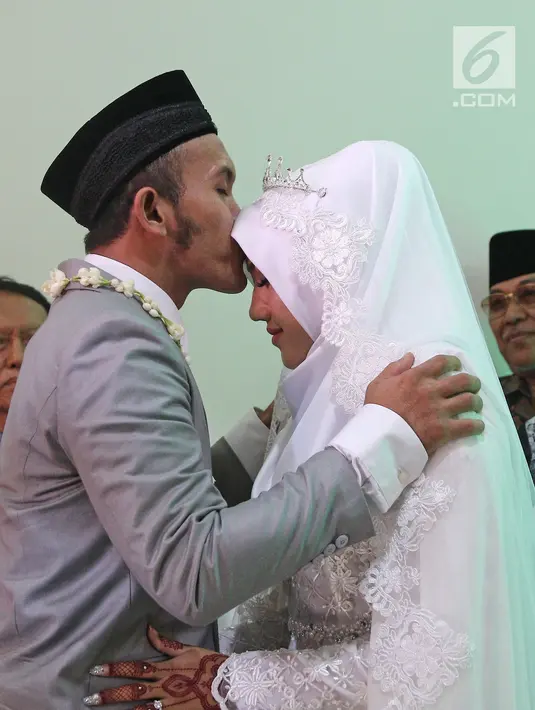 Komedian Caisar Aditya Putra mencium kening Intan Sri Mardiani usai resmi menikah di kawasan Cimahpar, Bogor, Jawa Barat, Sabtu (30/6). Caisar menyusul langkah mantan istrinya, Indadari untuk kembali menikah. (Liputan6.com/Herman Zakharia)