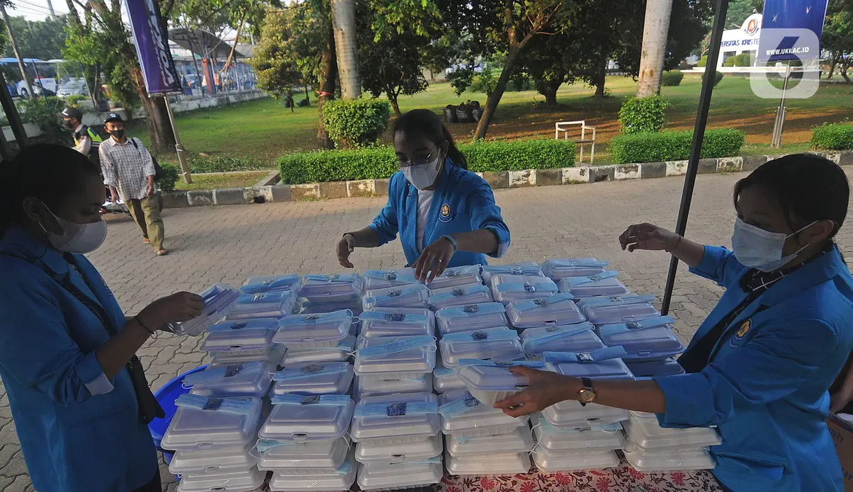 Mahasiswa menyiapkan makanan gratis untuk masyarakat di UKI, Cawang, Jakarta, Selasa (16/3/2021). Kegiatan ini memberikan 500 bungkus nasi, masker dan vitamin setiap harinya sejak pukul 06.00 WIB, untuk meringankan beban masyarakat di masa pandemi Covid-19. (Liputan6.com/Herman Zakharia)