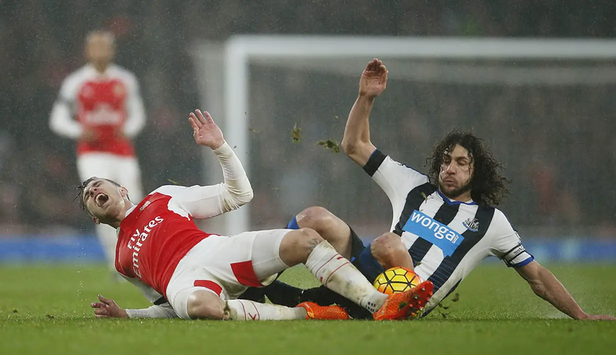 Gelandang Arsenal, Aaron Ramsey, ditekel bek Newcastle, Fabricio Coloccini, pada laga Liga Premier Inggris. Arsenal kini unggul dua poin dari Leicester yng berada di posisi kedua. (Reuters/Andrew Couldridge)