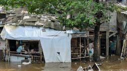 Tingginya intensitas hujan yang terjadi pada Minggu (6/7/2025) sore dan luapan air sungai terdekat menyebabkan banjir kembali melanda sejumlah wilayah Jakarta pada Senin pagi (7/7/2025). (BAY ISMOYO/AFP)