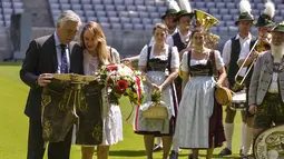 Carlo Ancelotti (kiri) bersama istrinya Mariann melihat celana tradisional Bavaria miliknya pada sesi foto dan perkenalan di Stadion klub FC Bayern Munich, Jerman, (11//7/2016). (AFP/Guenter Schiffmann)