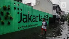 Seorang remaja melintasi banjir yang merendam lingkungan rumah tempat tinggal mereka di kawasan kecamatan Kebayoran Baru, Jakarta, Senin (25/01/2021). Hujan deras yang mengguyur Jakarta hari ini, Senin (25/1) menyebabkan terjadinya banjir di kawasan permukiman tersebut. (Liputan6.com/Johan Tallo)