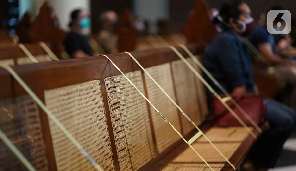 Jemaat duduk di antara pembatas jarak tubuh saat melaksanakan ibadah misa di Gereja Katedral Jakarta, Minggu (12/7/2020). Gereja Katedral Jakarta kembali menggelar misa bagi umat Katolik dengan menerapkan protokol kesehatan untuk mencegah penularan Covid-19. (Liputan6.com/Immanuel Antonius)