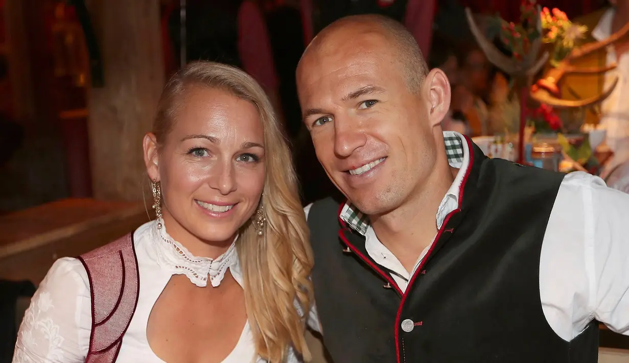 Gelandang Bayern Munchen, Arjen Robben bersama istrinya Bernadien Eillert tersenyum saat menghadiri acara Oktoberfest di Munich, Jerman (2/9). (REUTERS/Alexander Hassenstein)