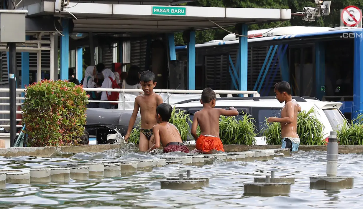 Anak-anak bermain di kolam air mancur penghias kawasan Pasar Baru, Jakarta, Selasa (29/1). Keterbatasan lahan bermain menyebabkan sebagian anak di Ibukota bermain tidak pada tempatnya, meskipun berbahaya bagi keselematan. (Liputan6.com/Immanuel Antonius)