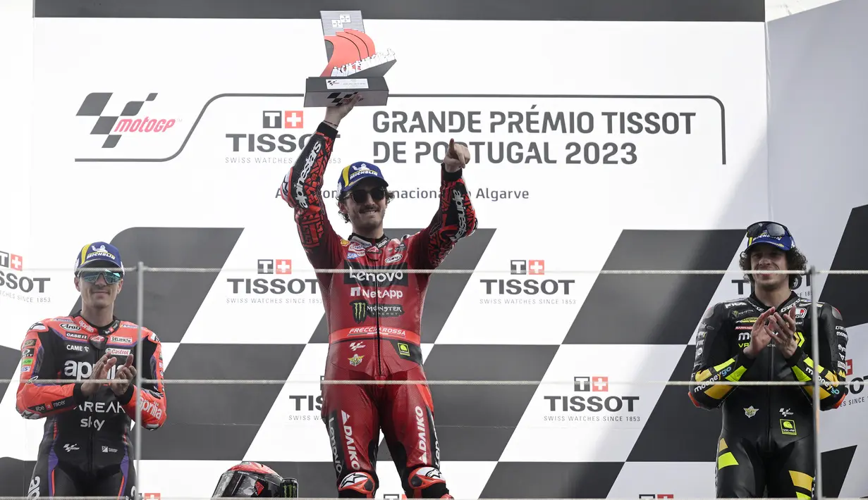 Selebrasi Pebalap Ducati Lenovo, Francesco Bagnaia di atas podium setelah menjuarai balapan MotoGP Portugal 2023 di Sirkuit Internasional Algarve, Portimao, Portugal, Minggu (26/3/2023). Posisi kedua ditempati pebalap Aprilia Racing, Maverick Vinales (kiri) dan posisi ketiga menjadi milik pebalap Mooney VR46 Ducati, Marco Bezzecchi (kanan). (AFP/Patricia De Melo Moreira)
