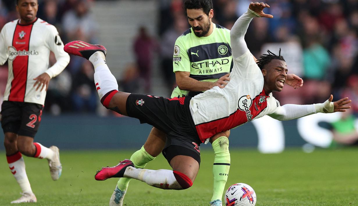 Pemain Southampton, Armel Bella-Kotchap (depan) berebut bola dengan pemain Manchester City, Ilkay Gundogan pada laga lanjutan Liga Inggris 2022/2023 di St Mary's Stadium, Southampton, Inggris 8 April 2023. Bella-Kotchap merupakan salah satu pemain muda andalan Southampton. Musim ini, Pria 21 tahun tersebut tercatat telah memainkan 26 laga di semua ajang dengan menyumbangkan 2 assist. (AFP/Adrian Dennis)
