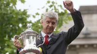 Pelatih Arsenal, Arsene Wenger memegang piala yang diraihnya dalam ajang Piala FA, saat melakukan parade keliling kota di London, Inggris, (31/5/2015). Ini merupakan kali ke 12 bagi Arsenal menjuarai Piala FA. (REUTERS/Neil Hall)