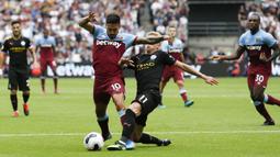 Gelandang Manchester City, Oleksandr Zinchenko, berebut bola dengan gelandang West Ham, Manuel Lanzini, pada laga Premier League di Stadion London, London, Sabtu (10/8). West Ham kalah 0-5 dari City. (AFP/Ian Kington)