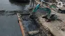 Alat berat mengangkat material endapan lumpur di Kampung Nelayan Cilincing, Jakarta Utara, Kamis (2/9/2021). Pengerukan dilakukan untuk mengurangi pendangkalan di muara teluk Jakarta serta penataan sandaran kapal-kapal tradisional. (merdeka.com/Imam Buhori)