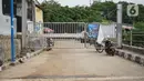 Suasana gerbang jalur inspeksi Sungai Ciliwung yang ditutup di kawasan Kampung Melayu, Jakarta, Selasa (14/7/2020). Penutupan tersebut dilakukan untuk membatasi mobilitas warga sehingga dapat meminimalisasi penyebaran COVID-19. (Liputan6.com/Immanuel Antonius)