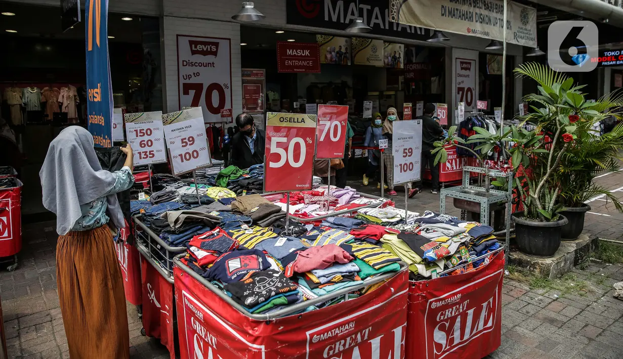 Pengunjung melihat pakaian yang dijajakan di salah satu tenant di Pasar Baru, Jakarta, Rabu (5/4/2021). Memasuki minggu terakhir bulan Ramadhan 2021, Pasar Baru tampak sepi pengunjung. (Liputan6.com/Faizal Fanani)