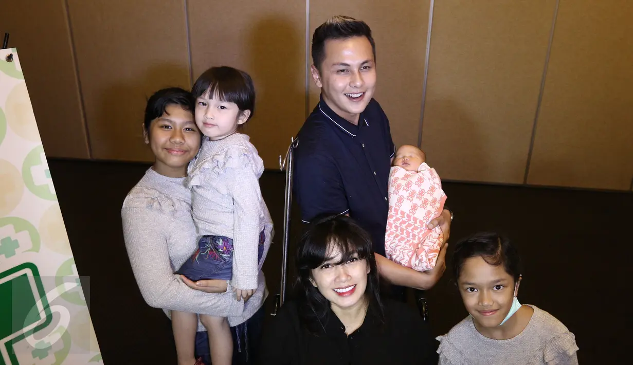 Pasangan selebritis Ussy Sulistiawaty dan Andhika Pratama berpose bersama keluarga kecilnya usai menggelar konferensi pers kelahiran anak ke-4 mereka di RS Pondok Indah, Jakarta, Senin (6/3). (Liputan6.com/Herman Zakharia)
