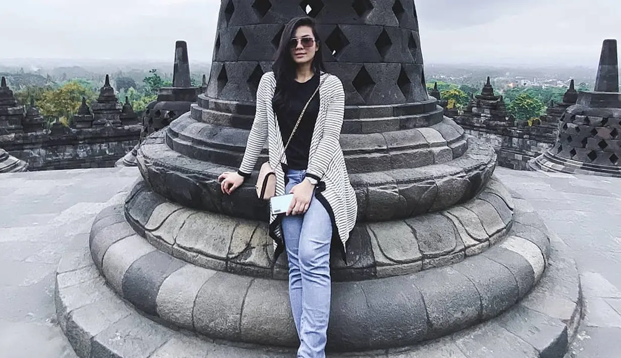 Saat dirinya tengah berlibur di Candi Borobudur, Eriska pun memilih menggunakan penampilan santai dengan celana denim serta baju berwarna hitam. Penampilan tersebut ia padukan dengan cardigan serta sebuah sling bag mini dan kacamata. (Liputan6.com/IG/@eriskarein)