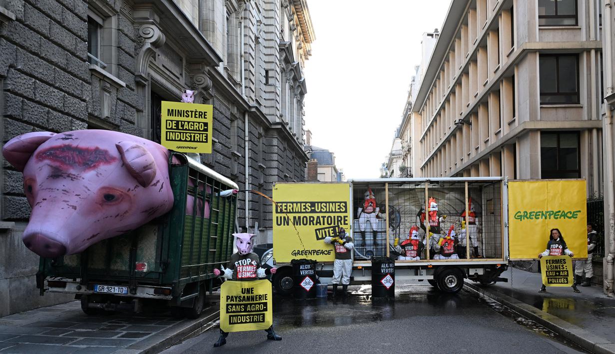 Peserta aksi juga menggunakan topeng mirip hewan ternak. (Miguel MEDINA/AFP)