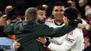 Ada kejadian menarik setelah gol ketiga MU yang dicetak oleh Bruno Fernandes. Seorang suporter lolos dari kawalan petugas dan melakukan selebrasi bersama Bruno Fernandes, Casemiro, dan Lisandro Martinez. (AFP/Darren Staples)