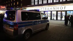 Kendaraan polisi terparkir di sekitar sebuah stasiun di Dusseldorf, Jerman, setelah serangan kapak yang dilakukan seorang pria, Kamis (9/3). Meski serangan dilakukan satu orang, namun aparat keamanan setempat menangkap dua tersangka. (Patrik STOLLARZ/AFP)