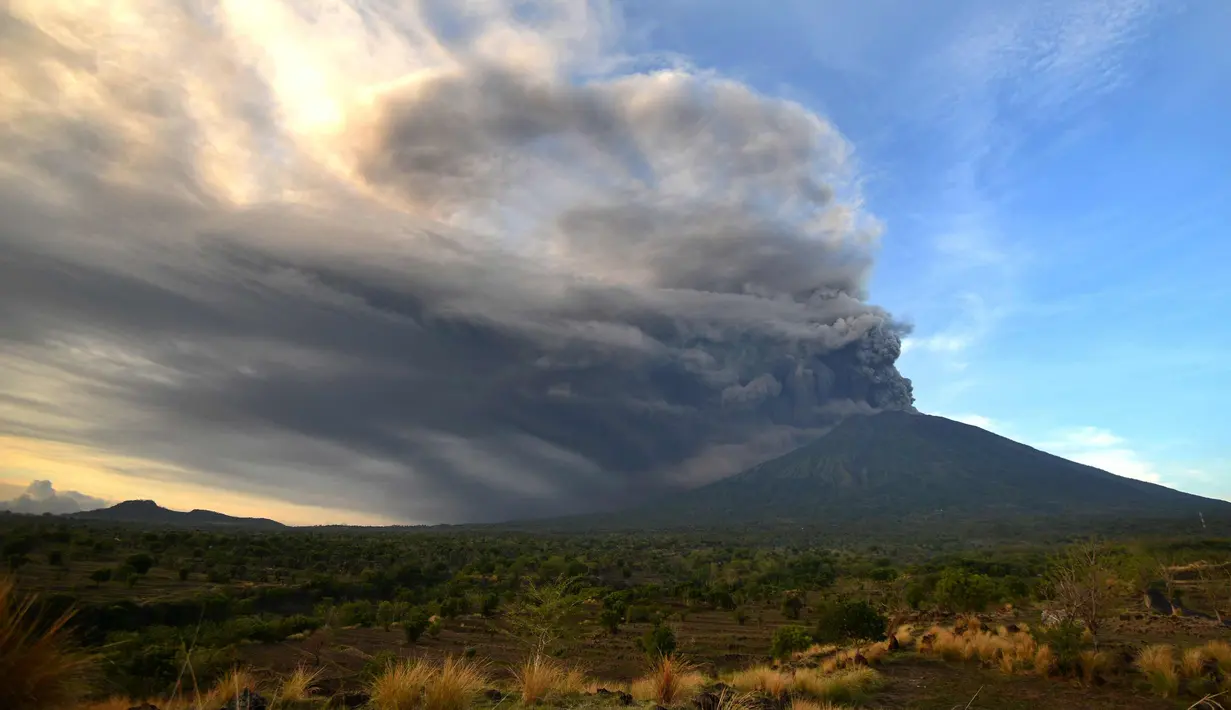 Pemandangan Gunung Agung yang mengeluarkan abu vulkanik di Kecamatan Kubu, Karangasem, Bali, Minggu (26/11). Semburan asap dan abu vulkanik Gunung Agung mencapai ketinggian 1.500 meter dari puncak Gunung Agung. (AFP/Sonny Tumbelaka)
