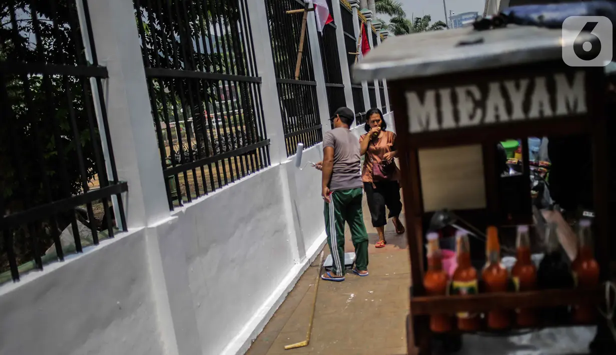 Pekerja melakukan pengecatan tembok pagar di kompleks Parlemen Gedung DPR/MPR, Senayan, Jakarta, Rabu (16/10/2019). Jelang pelantikan presiden dan wakil presiden pada 20 Oktober, berbagai persiapan dilakukan, salah satunya mempercantik pagar di depan pintu masuk. (Liputan6.com/Faizal Fanani)