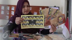 Petugas menunjukan perangko edisi Gerhana Matahari Total di Kantor Pos Indonesia, Jakarta, (25/2). Perangko ini dijual Rp 3 ribu hingga Rp 72 ribu fullset. (Liputan6.com/Angga Yuniar)