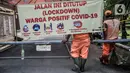 Petugas PPSU membersihkan lingkungan saat pemberlakuan karantina wilayah skala kecil atau mini lockdown di RT 011 RW 009, Kelurahan Kayu Putih, Pulogadung, Jakarta Timur, Minggu (6/6/2021). Warga terpapar akibat sering berkerumun di taman di wilayah tersebut. (merdeka.com/Iqbal S. Nugroho)