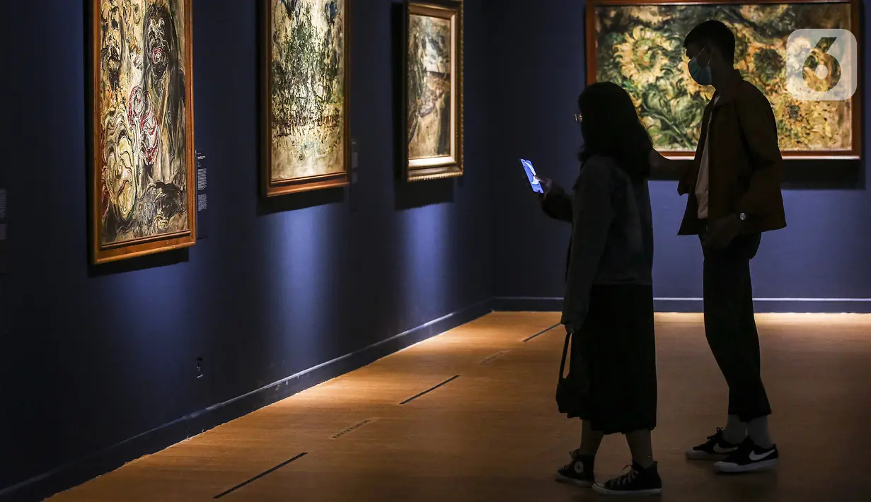 Pengunjung melihat karya proyeksi video mapping di pameran imersif Affandi: Alam, Ruang, Manusia di Galeri Nasional Indonesia, Jakarta, Rabu (28/10/2020). Pengunjung yang melihat pameran harus melakukan protokol kesehatan dan dibatasi hanya 20 penonton per sesi kunjungan. (Liputan6.com/Johan Tallo)